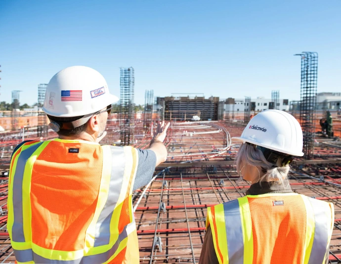 two construction workers in safety vests at site